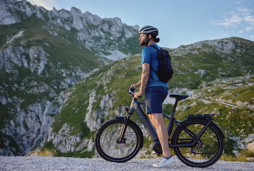 Un hombre se desplaza en su bicicleta eléctrica Gazelle, mientras una majestuosa montaña con nieve se perfila en la distancia. La Eclipse C380 HMB, equipada con transmisión por correa y cuadro de paso alto, supera los límites de las ciudades holandesas. Descubre la innovadora propuesta de Gazelle para conquistar los terrenos estadounidenses.