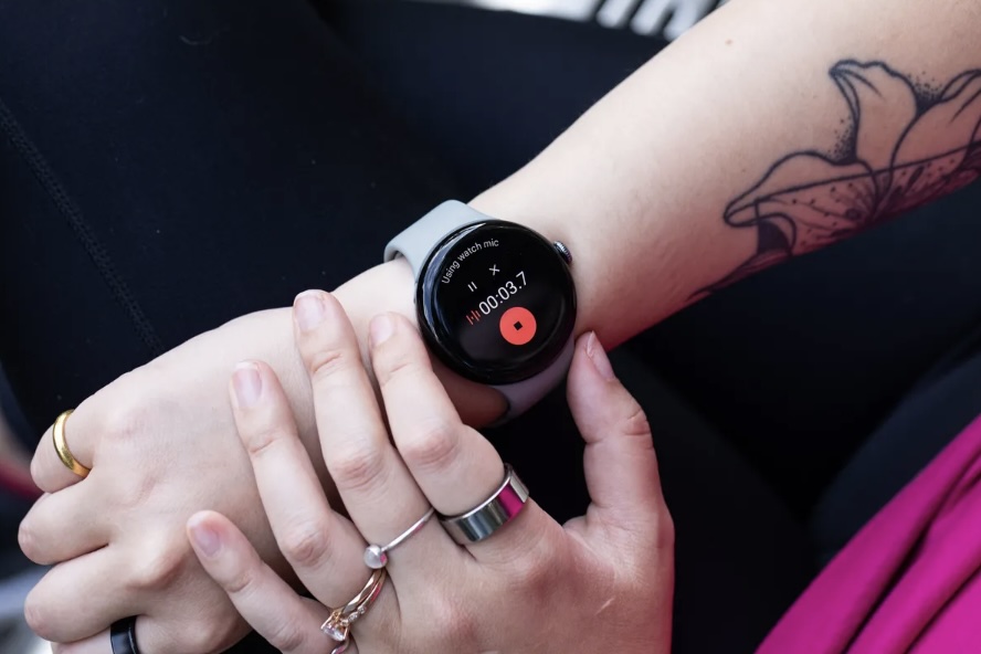 Wear OS 5 y la Aplicación Grabadora: Novedades para los Modelos Más Antiguos de Pixel Watch Por Victoria Song, reportera senior enfocada en dispositivos portátiles, tecnología de salud y más, con 12 años de experiencia. Antes de unirse a The Verge, trabajó para Gizmodo y PC Magazine. 24 de septiembre de 2024 a las 5:00 PM GMT-3 Si tienes un Pixel Watch original o un Pixel Watch 2, ¡buenas noticias! Wear OS 5 comenzará a implementarse hoy, trayendo consigo un puñado de nuevas funciones que mejorarán tu experiencia. La más interesante es la aplicación Grabadora, que originalmente fue exclusiva para el Pixel Watch 3. Esta herramienta te permite grabar audio directamente desde tu muñeca, y posteriormente puedes acceder a la grabación junto con una transcripción en tu teléfono. (Es importante mencionar que esta función requiere tener un teléfono Pixel). Entre las otras actualizaciones se incluyen: Controles de cámara mejorados que facilitan la toma de fotos. Lanzador de aplicaciones en vista de cuadrícula, una sorpresa agradable que permite una navegación más intuitiva entre las aplicaciones, a diferencia del formato de lista anterior, que podía ser tedioso si tenías demasiadas aplicaciones instaladas. Wear OS 5 también introduce mejoras significativas en la gestión de la batería. Durante el evento I/O de Google a principios de este año, se mencionó que correr un maratón consumiría alrededor del 20% menos de duración de batería, lo que es una excelente noticia para los entusiastas del deporte. No te preocupes si no ves la actualización de inmediato; aunque el despliegue comienza hoy, Google ha indicado que continuará a lo largo de la semana en fases, dependiendo del operador y del dispositivo.